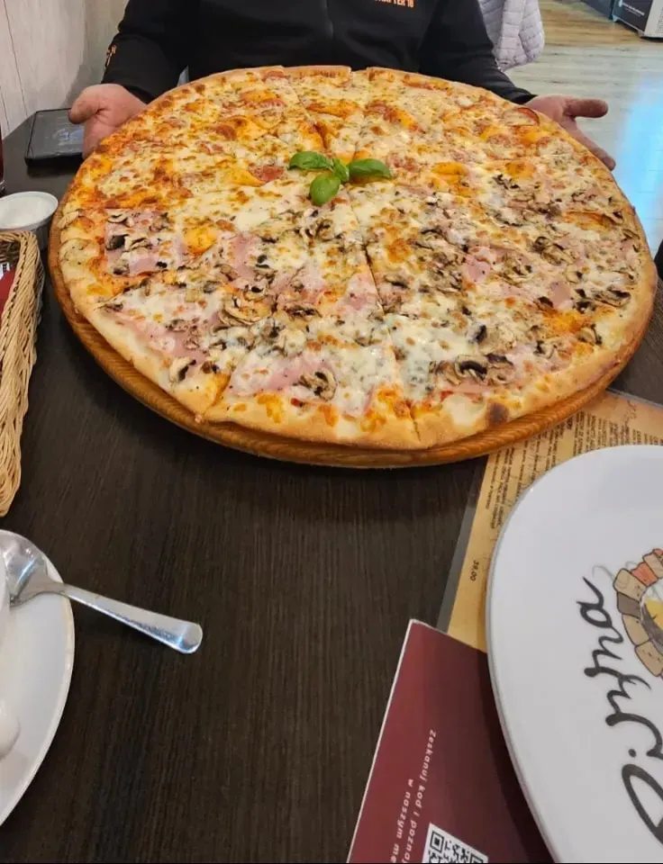 Pizza z szynką parmeńską, rukolą i parmezanem