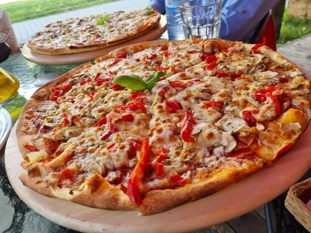 Pizza z czerwoną papryką, serem i listkiem bazylii